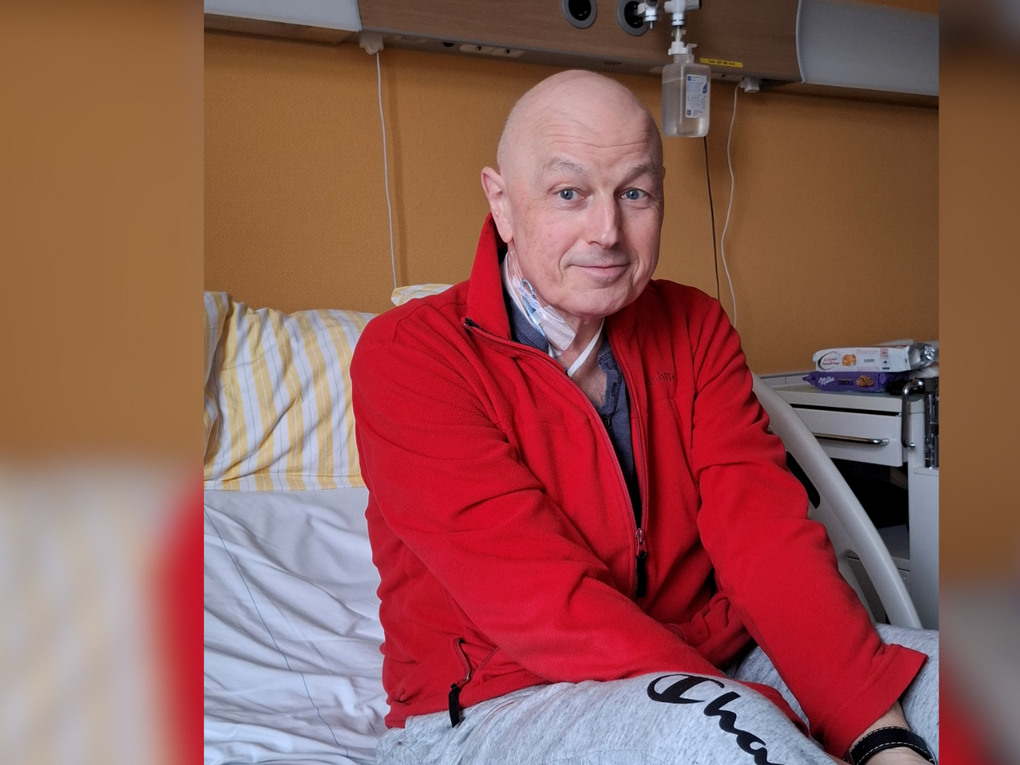 Ein Mann sitzt in einem Krankenhausbett Ein Mann sitzt in einem Krankenhausbett