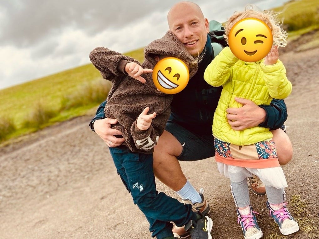Ein Mann hält zwei Kinder in den Armen. Ein Mann hält zwei Kinder in den Armen.