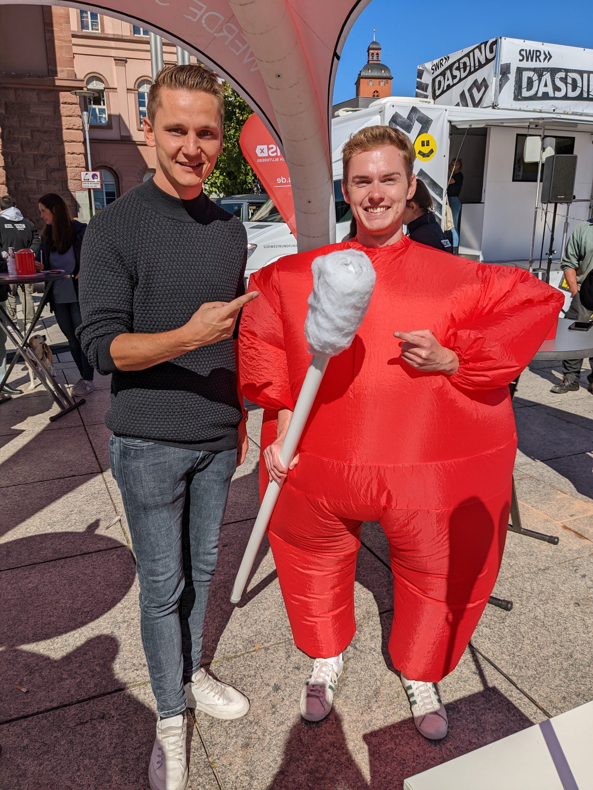Ein Mann in einem roten Kleidungsstück mit einem Wattestäbchen Ein Mann in einem roten Kleidungsstück mit einem Wattestäbchen