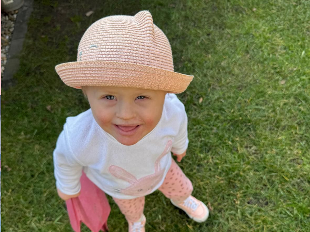 Ein Kleinkind im Gras stehend mit einem Hut auf und ein Tuch in der Hand. Ein Kleinkind im Gras stehend mit einem Hut auf und ein Tuch in der Hand.