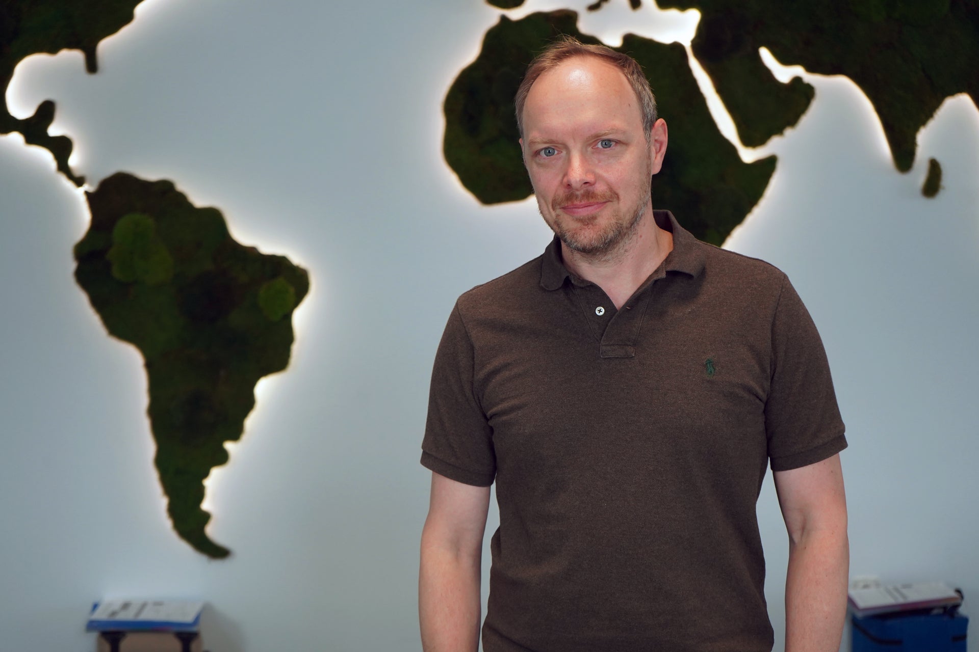 Marco Dehler, time:matters GmbH steht vor einer Weltkarte Marco Dehler, time:matters GmbH steht vor einer Weltkarte