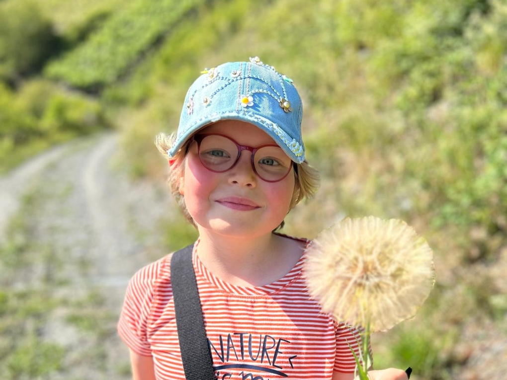 Ein Mädchen hält einen Löwenzahn Ein Mädchen hält einen Löwenzahn