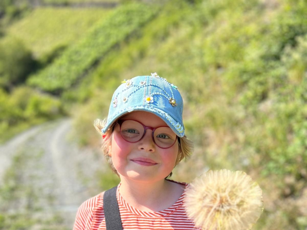 Ein Mädchen hält einen Löwenzahn Ein Mädchen hält einen Löwenzahn