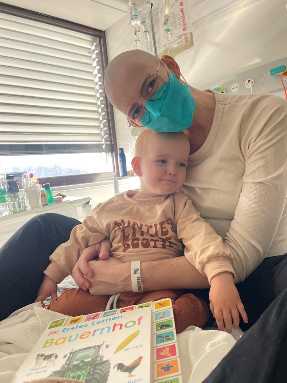 Eine Frau mit einer Maske hält ein Baby Eine Frau mit einer Maske hält ein Baby