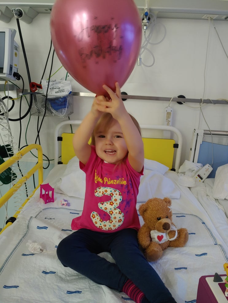 Die kleine Blutkrebspatientin Ida im Krankenhausbett mit einem Ballon in der Hand