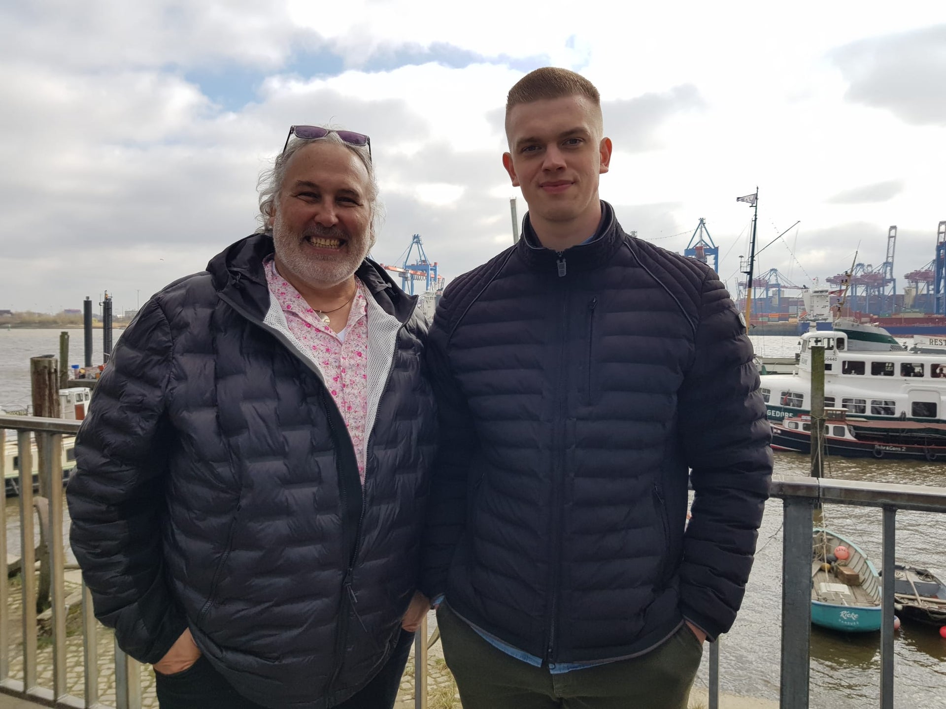 Arno und Nico stehen nebeneinander und lächeln in die Kamera Arno und Nico stehen nebeneinander und lächeln in die Kamera