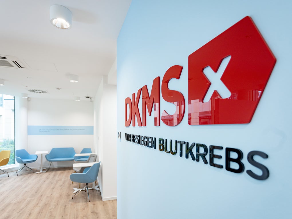 Innenansicht eines DKMS-Büros mit Logo an der Wand und Wartebereich mit Sesseln. Innenansicht eines DKMS-Büros mit Logo an der Wand und Wartebereich mit Sesseln.