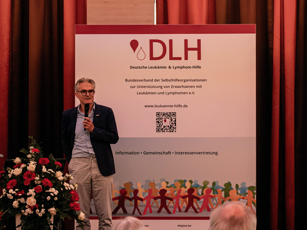 Ein Mann steht auf einer Bühne mit einem Mikrofon. Ein Mann steht auf einer Bühne mit einem Mikrofon.