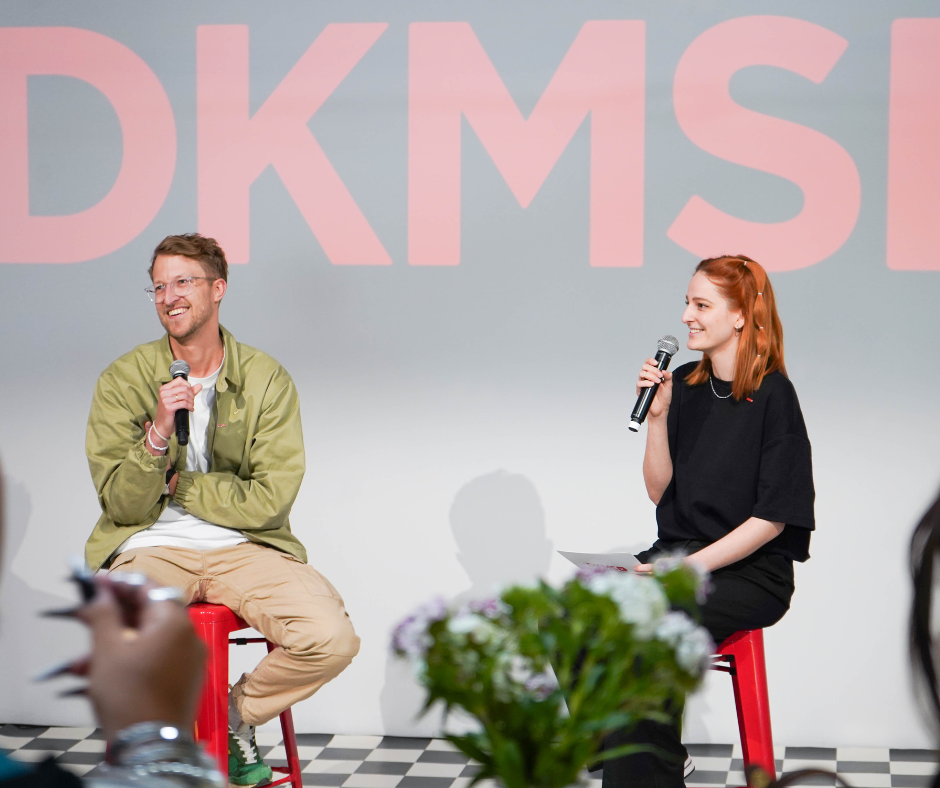 Ein Mann und eine Frau sitzen auf Hockern mit Mikrofonen Ein Mann und eine Frau sitzen auf Hockern mit Mikrofonen