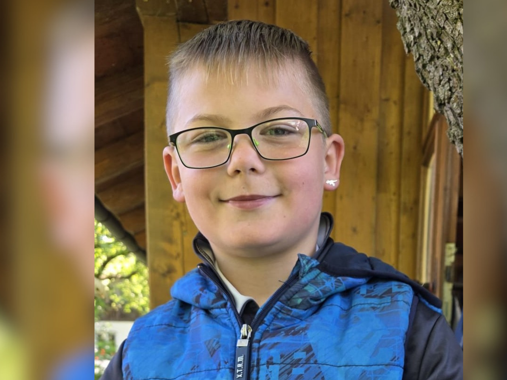 Ein Junge trägt eine Brille und eine blaue Jacke. Ein Junge trägt eine Brille und eine blaue Jacke.