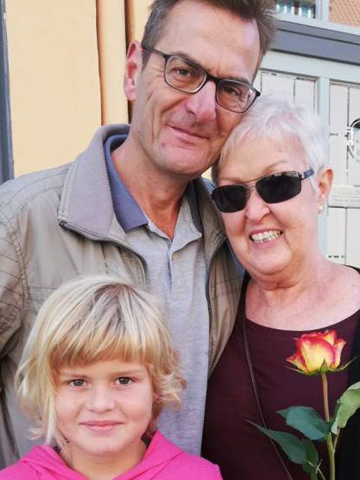 Ein Mann und eine Frau posieren für ein Foto mit einem Mädchen und einer Rose