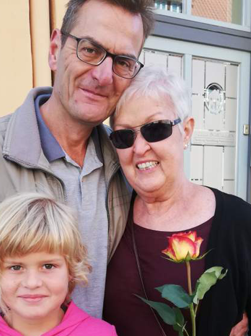 Ein Mann und eine Frau posieren für ein Foto mit einem Mädchen und einer Rose