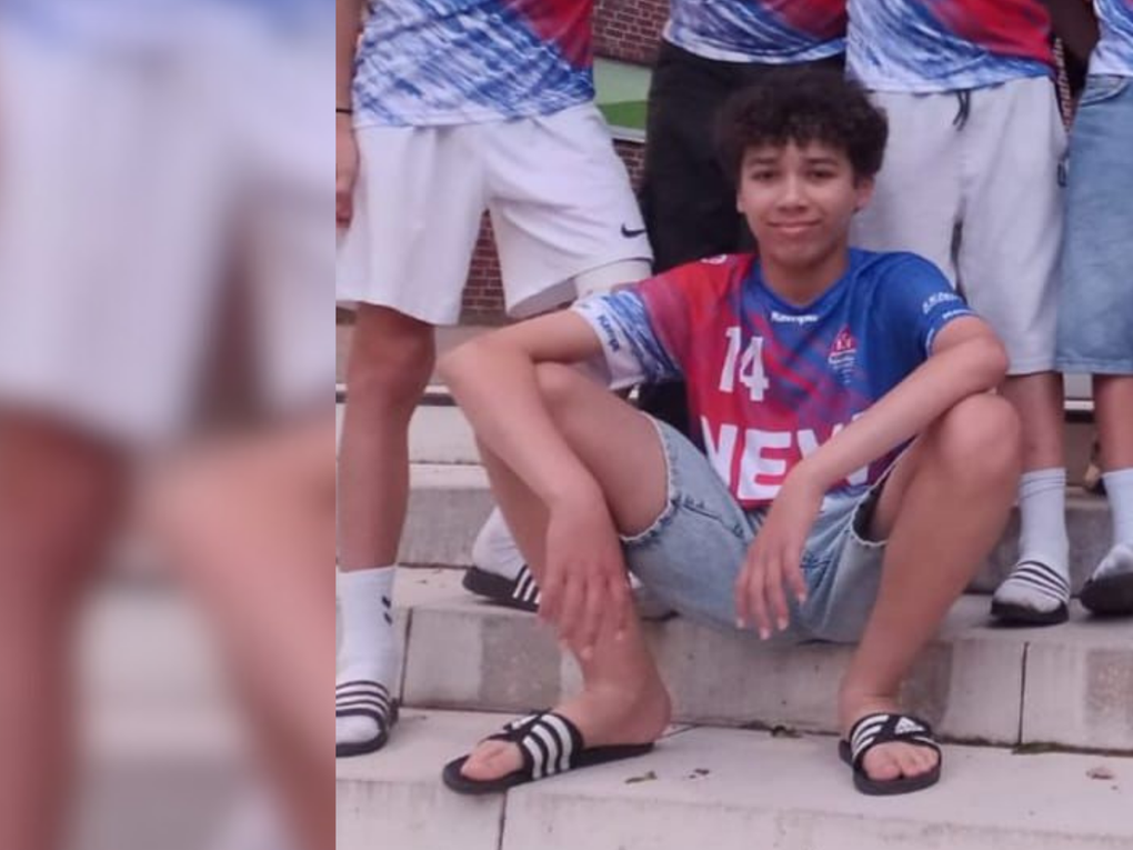 Ein Junge sitzt auf einer Treppenstufe und trägt ein Sportjersey. Ein Junge sitzt auf einer Treppenstufe und trägt ein Sportjersey.