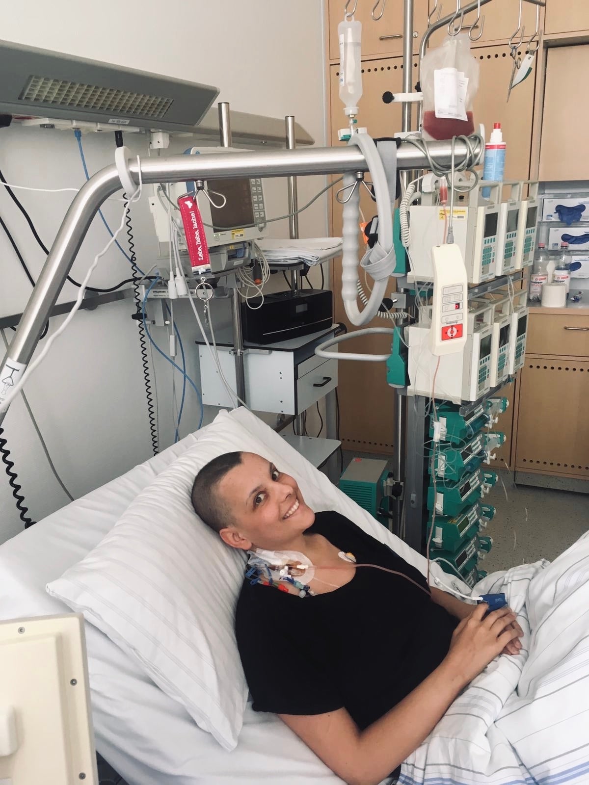 Janina erhält die überlebenswichtige Stammzellspende, sie liegt in einem Bett und lächelt für das Foto Janina erhält die überlebenswichtige Stammzellspende, sie liegt in einem Bett und lächelt für das Foto