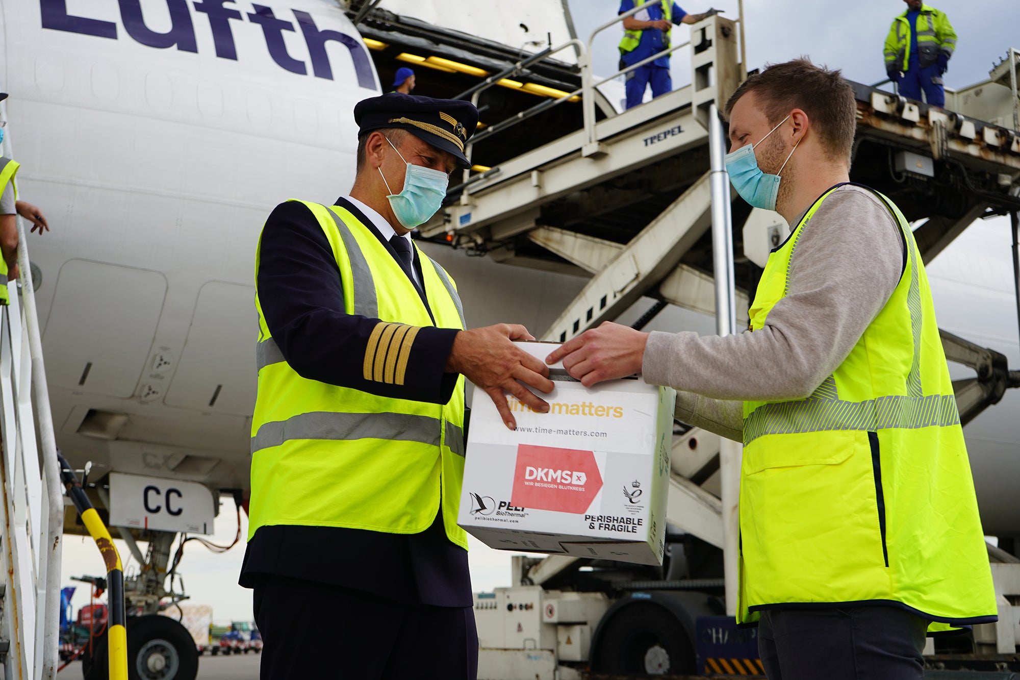 Übergabe der Transportbox vor der Maschine der Lufthansa Cargo