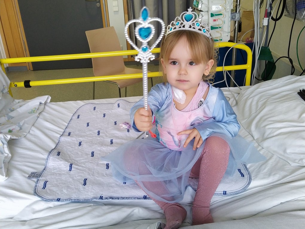 Ein Mädchen in einem Prinzessinnen-Kleid und Krone, sitzt auf einem Krankenhausbett Ein Mädchen in einem Prinzessinnen-Kleid und Krone, sitzt auf einem Krankenhausbett