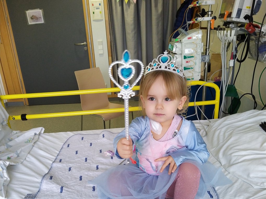 Ein Mädchen in einem Prinzessinnen-Kleid und Krone, sitzt auf einem Krankenhausbett Ein Mädchen in einem Prinzessinnen-Kleid und Krone, sitzt auf einem Krankenhausbett