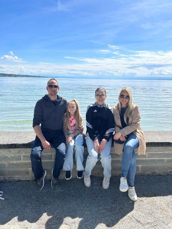 Patient Dominik mit seiner Familie vor einer schönen Meerkulisse. Patient Dominik mit seiner Familie vor einer schönen Meerkulisse.