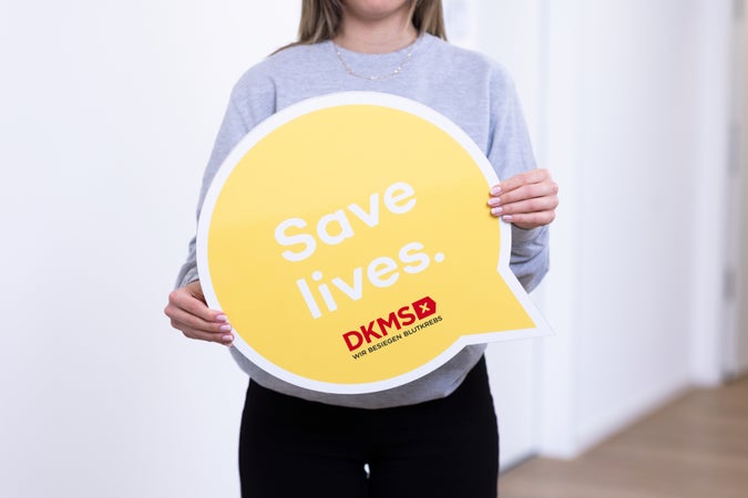 Eine Frau hält ein gelbes Schild Eine Frau hält ein gelbes Schild