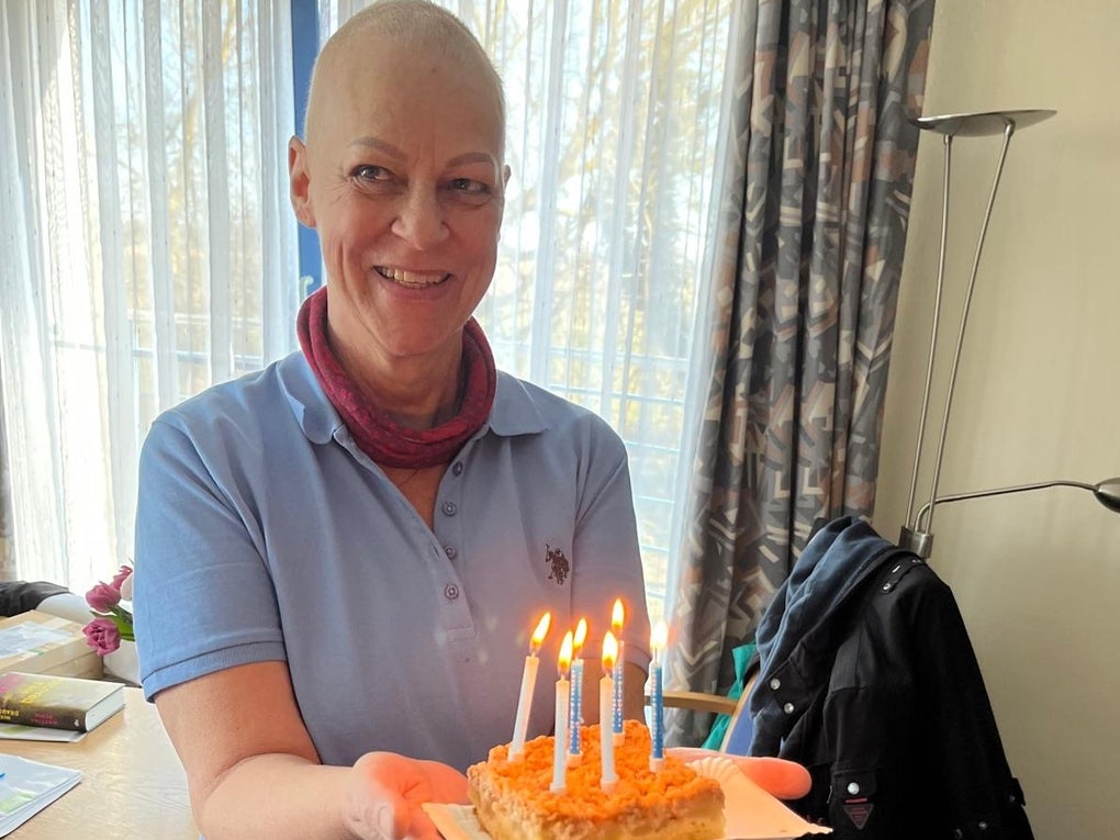 Eine Frau hält einen Kuchen mit Kerzen Eine Frau hält einen Kuchen mit Kerzen