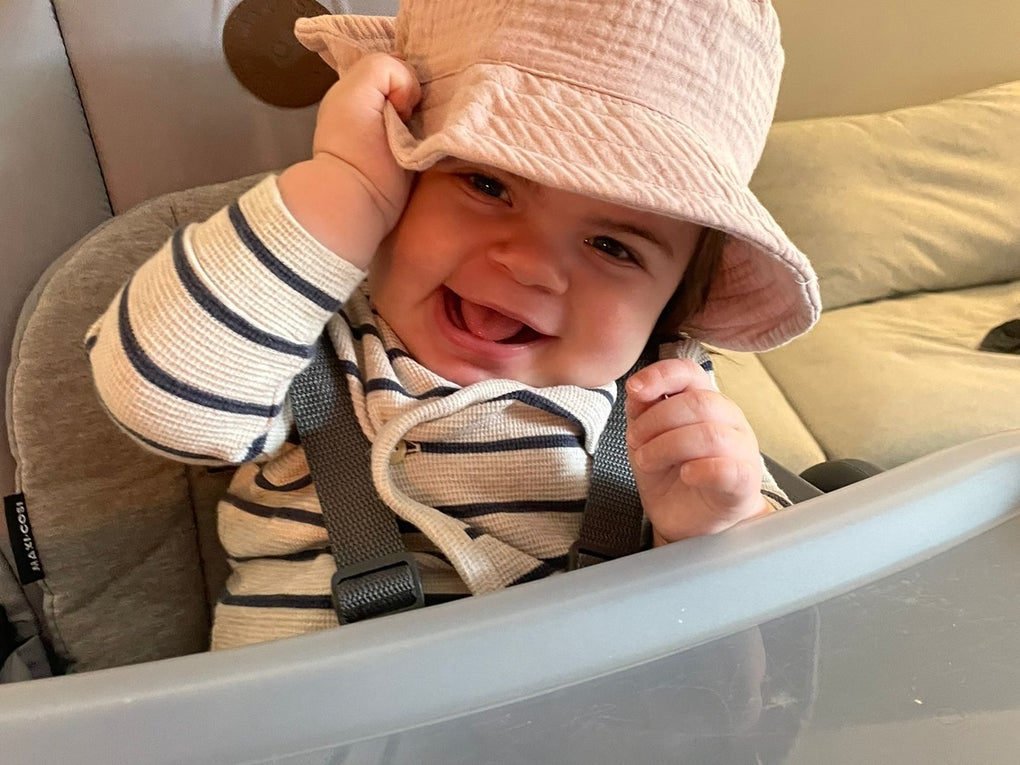 kleines Kind sitzt in einem Hochstuhl und grinst kleines Kind sitzt in einem Hochstuhl und grinst