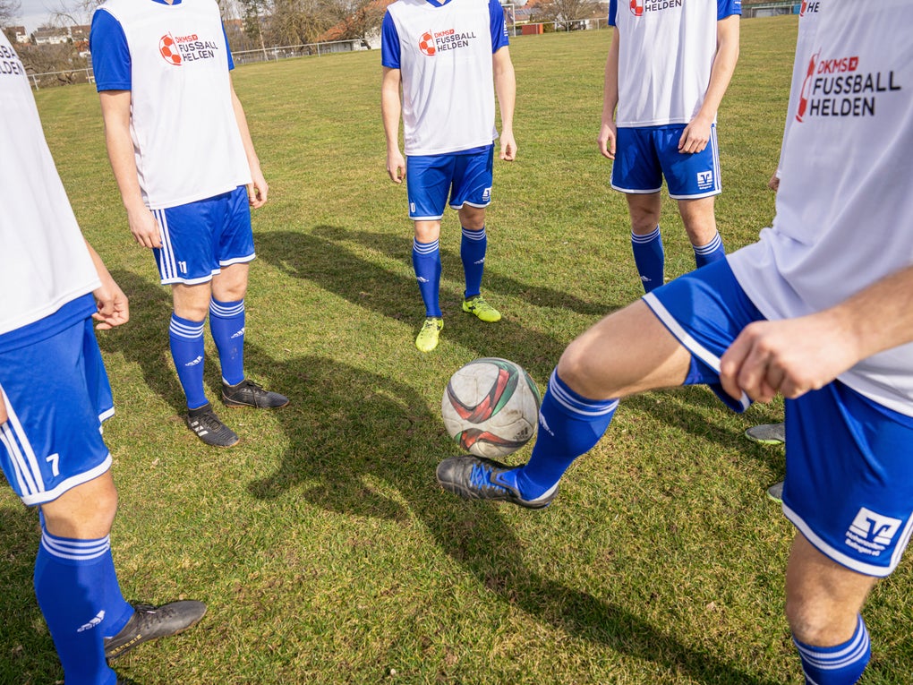 Eine Gruppe von Männern in Fußballtrikots auf einem Feld Eine Gruppe von Männern in Fußballtrikots auf einem Feld