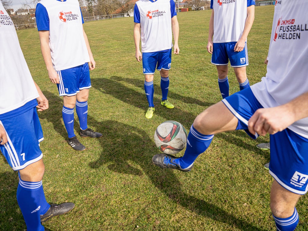Eine Gruppe von Männern in Fußballtrikots auf einem Feld Eine Gruppe von Männern in Fußballtrikots auf einem Feld