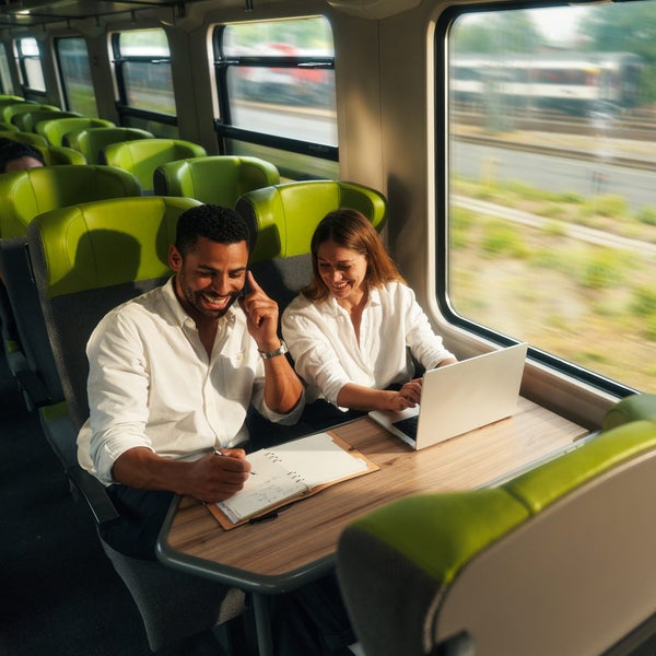 Ein Mann und eine Frau sitzen an einem Tisch mit einem Laptop Ein Mann und eine Frau sitzen an einem Tisch mit einem Laptop