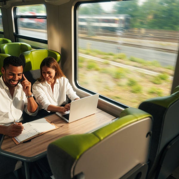 Ein Mann und eine Frau sitzen an einem Tisch mit einem Laptop Ein Mann und eine Frau sitzen an einem Tisch mit einem Laptop