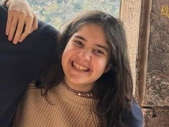 Ein Mädchen, das lächelnd den Arm um eine andere Person legt. Ein Mädchen, das lächelnd den Arm um eine andere Person legt.