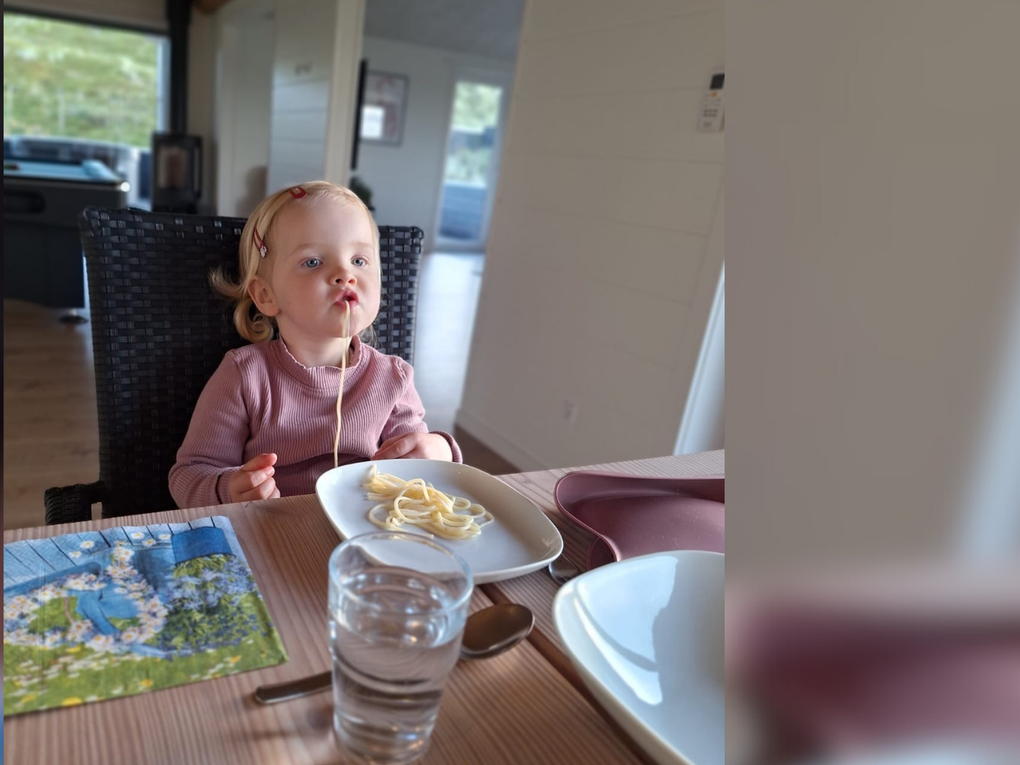 Ein kleines Mädchen sitzt an einem Tisch und isst Spaghetti. Ein kleines Mädchen sitzt an einem Tisch und isst Spaghetti.
