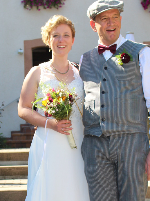 Ein Mann und eine Frau posieren in Hochzeitskleidung für ein Foto