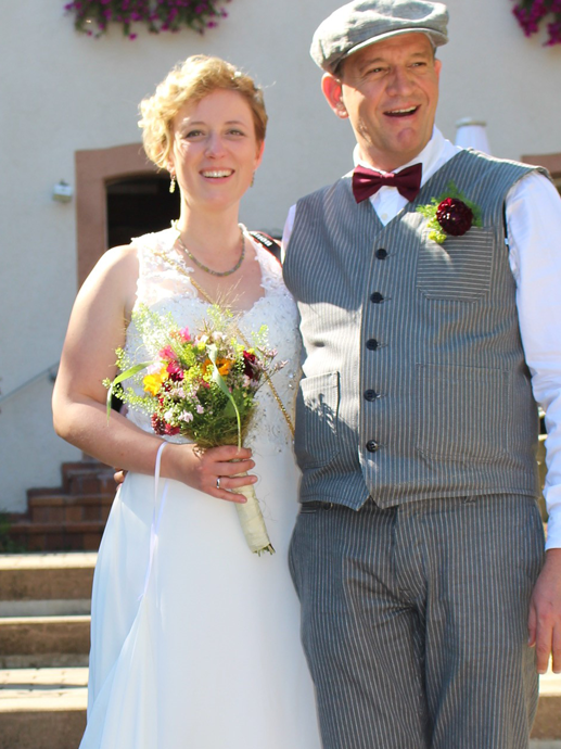 Ein Mann und eine Frau posieren in Hochzeitskleidung für ein Foto