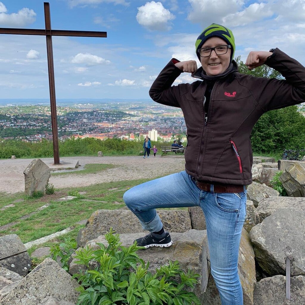 Eine Person, die ihre Muskeln auf Felsen anspannt Eine Person, die ihre Muskeln auf Felsen anspannt