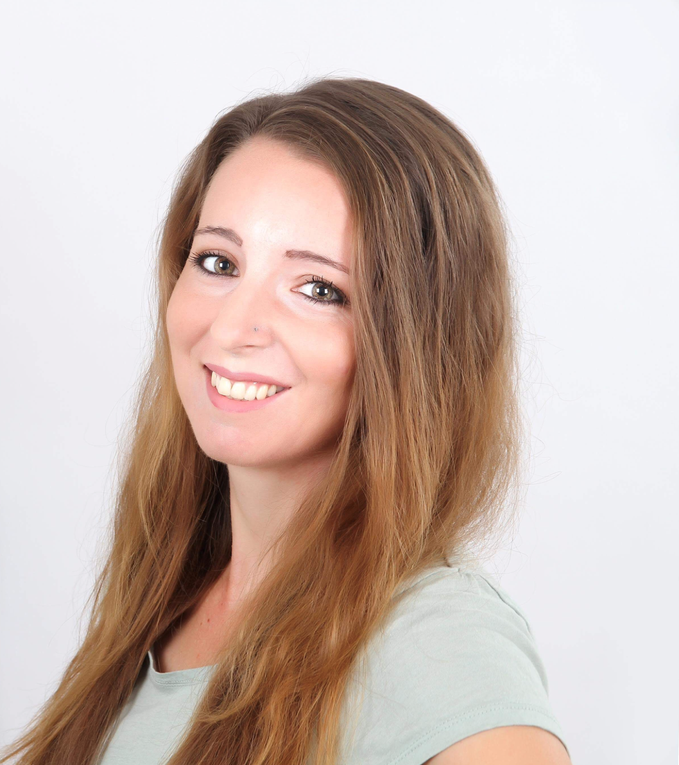 Eine Frau mit braunen Haaren Lächelt in die Kamera. Eine Frau mit braunen Haaren Lächelt in die Kamera.