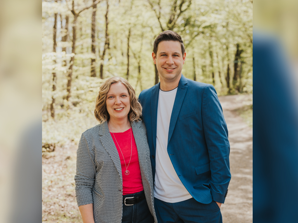 Eine Frau und ein Mann stehen Arm in Arm in einem Wald. Eine Frau und ein Mann stehen Arm in Arm in einem Wald.