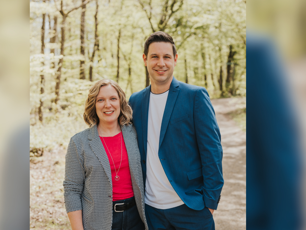 Eine Frau und ein Mann stehen Arm in Arm in einem Wald. Eine Frau und ein Mann stehen Arm in Arm in einem Wald.