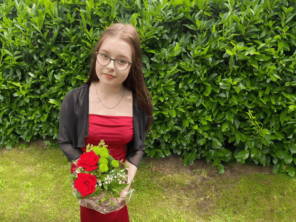 Angelina in einem roten Kleid hält einen Blumenstrauß Angelina in einem roten Kleid hält einen Blumenstrauß