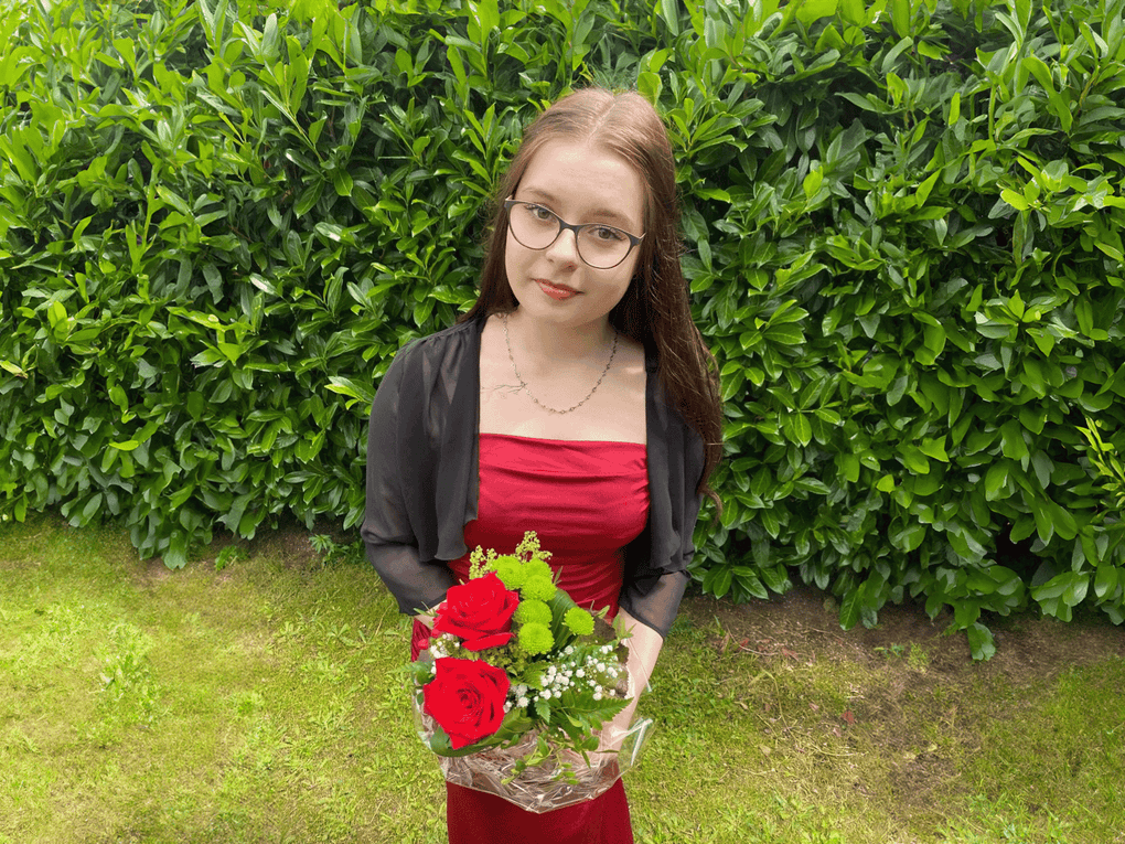 Angelina in einem roten Kleid hält einen Blumenstrauß Angelina in einem roten Kleid hält einen Blumenstrauß