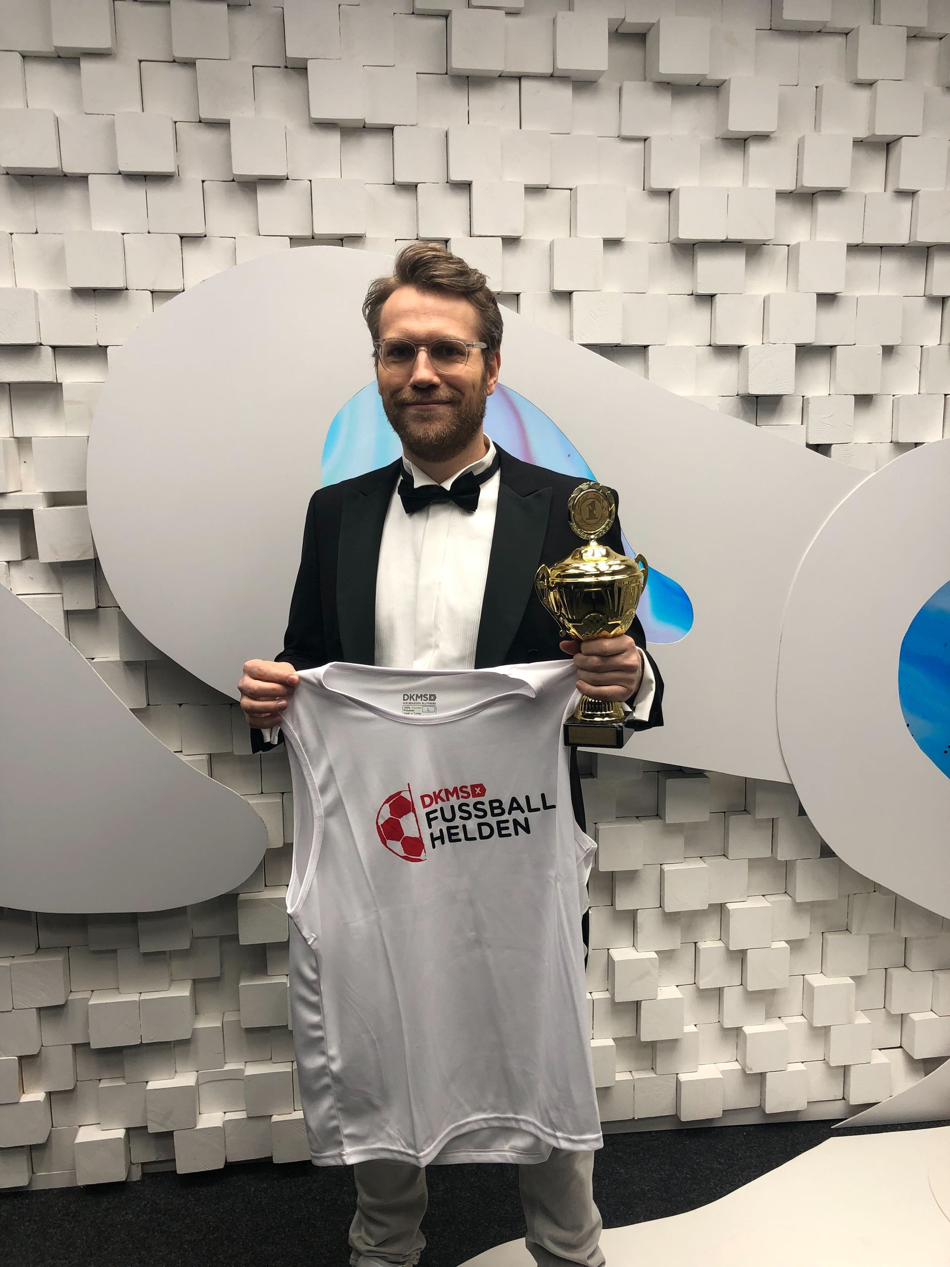 Ein Mann mit einer Trophäe und einem Hemd Ein Mann mit einer Trophäe und einem Hemd