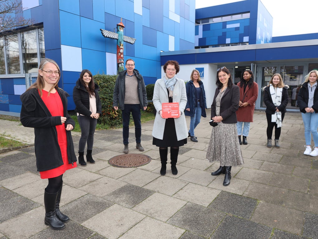Mehrere Personen halten DKMS Schulsiegel Mehrere Personen halten DKMS Schulsiegel