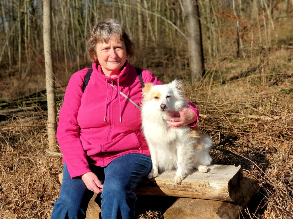 Agnes sitzt mit einem Hund auf einem Baumstamm Agnes sitzt mit einem Hund auf einem Baumstamm