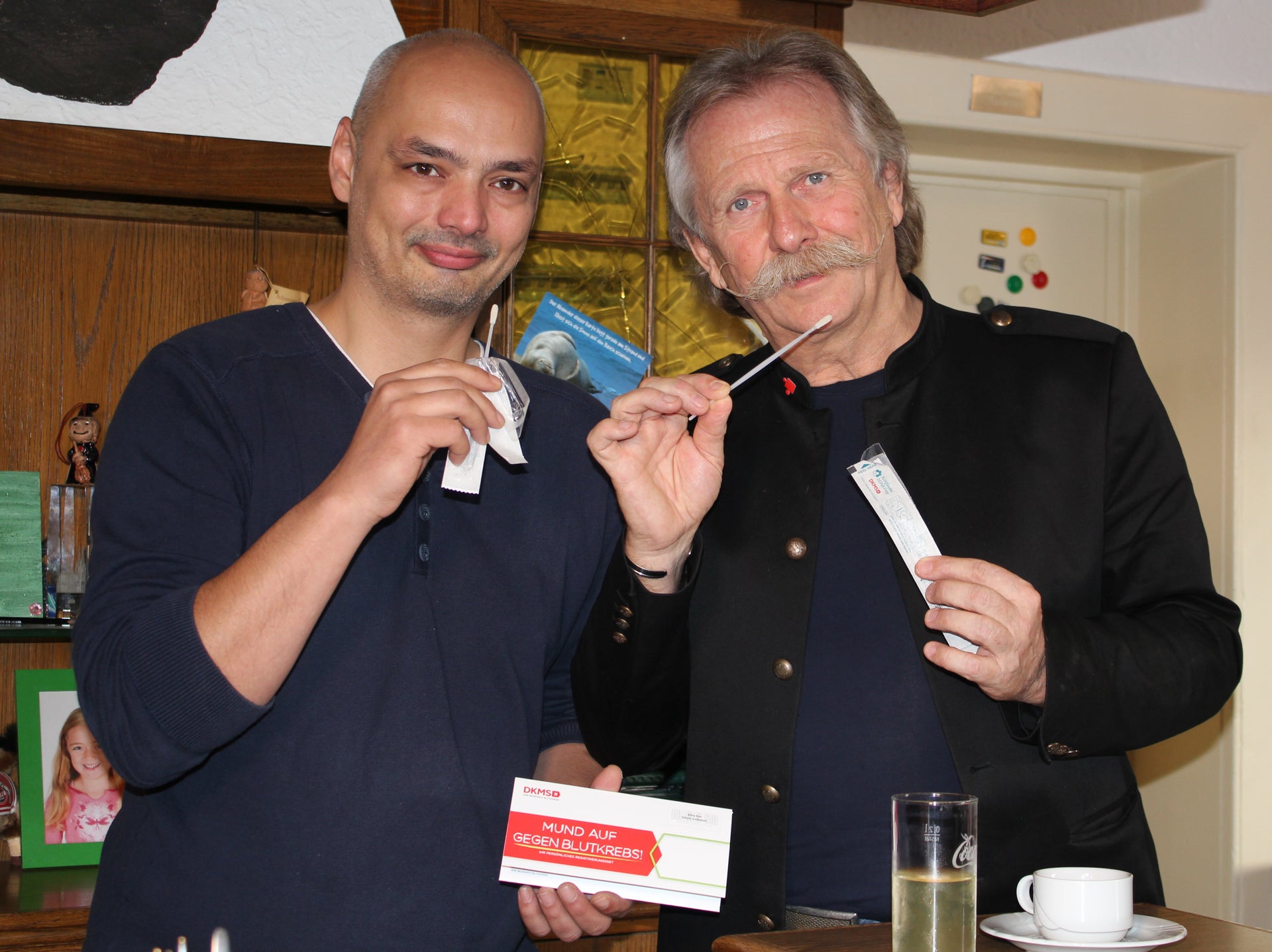 Gemeinsam mit Höhner-Frontmann Henning Krautmacher ruft Annikas Vater Alexander Breuer in seinem Restaurant Dom Eck zur Registrierung auf