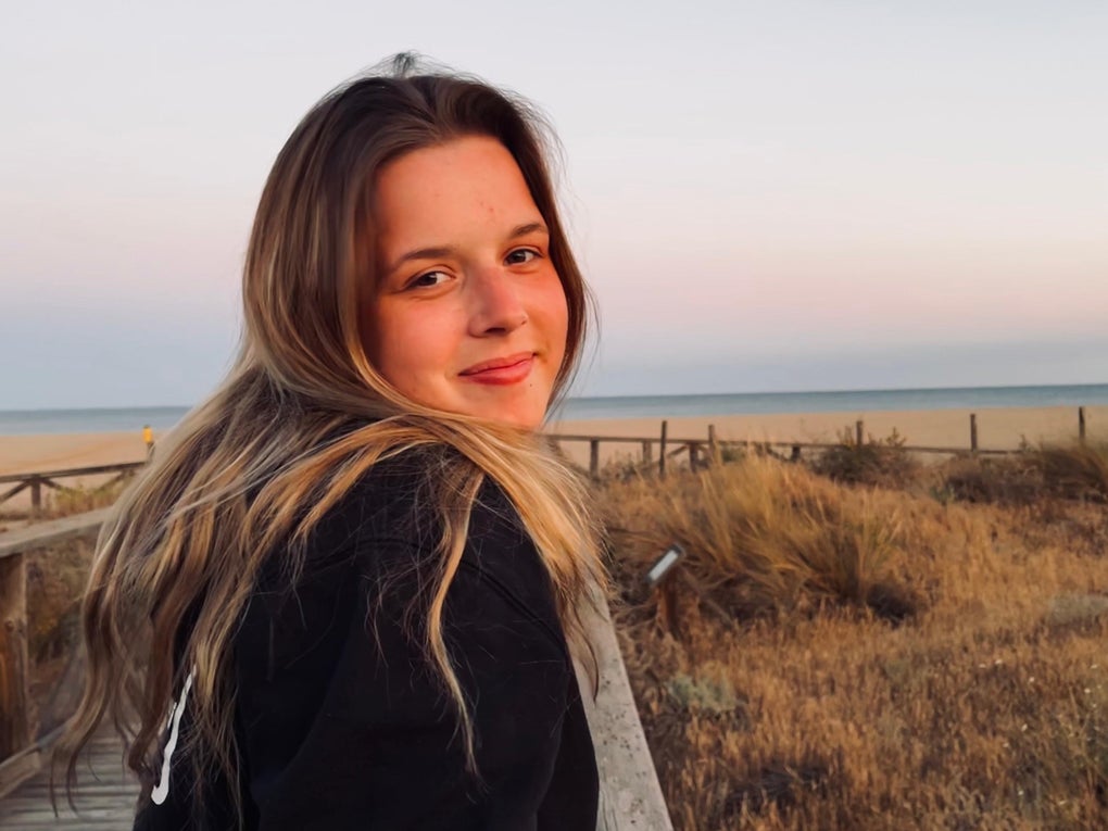 Julia steht am Strand und lächelt in die Kamera. Julia steht am Strand und lächelt in die Kamera.