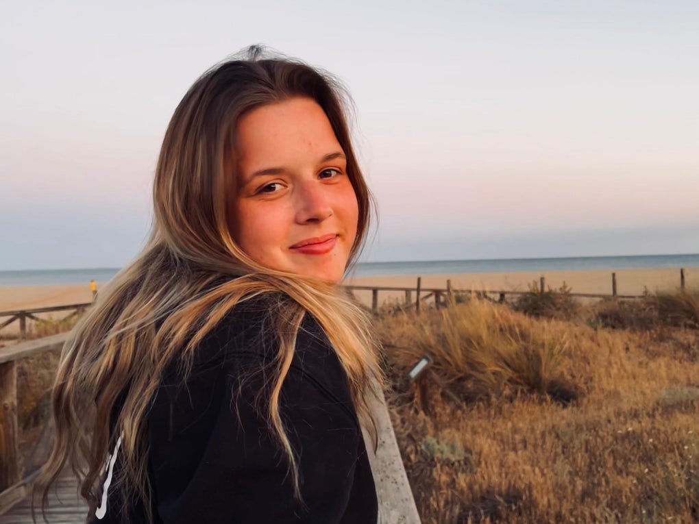 Julia steht am Strand und lächelt in die Kamera. Julia steht am Strand und lächelt in die Kamera.