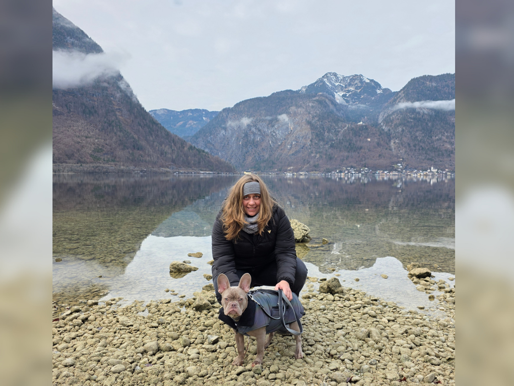 Eine Frau mit einem Hund an einem felsigen Strand Eine Frau mit einem Hund an einem felsigen Strand