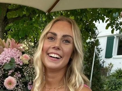 eine Frau mit pinkem Kleid lacht in die Kamera eine Frau mit pinkem Kleid lacht in die Kamera