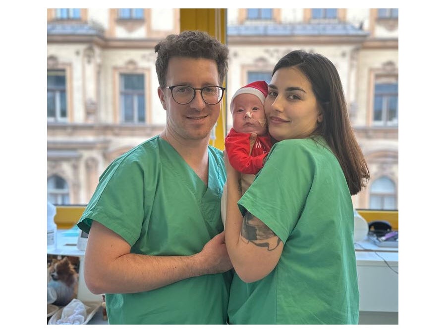 Patientin Elina, mit einer Weihnachtsmütze, im Arm ihrer Eltern.