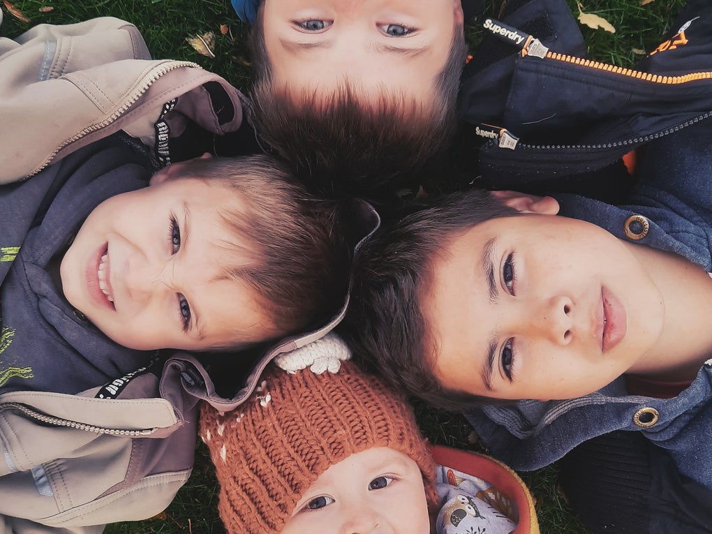 Eine Gruppe von Kindern liegt im Gras Eine Gruppe von Kindern liegt im Gras