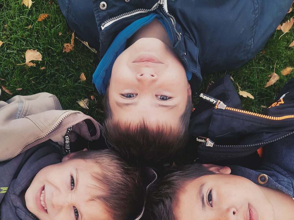 Eine Gruppe von Kindern liegt im Gras Eine Gruppe von Kindern liegt im Gras